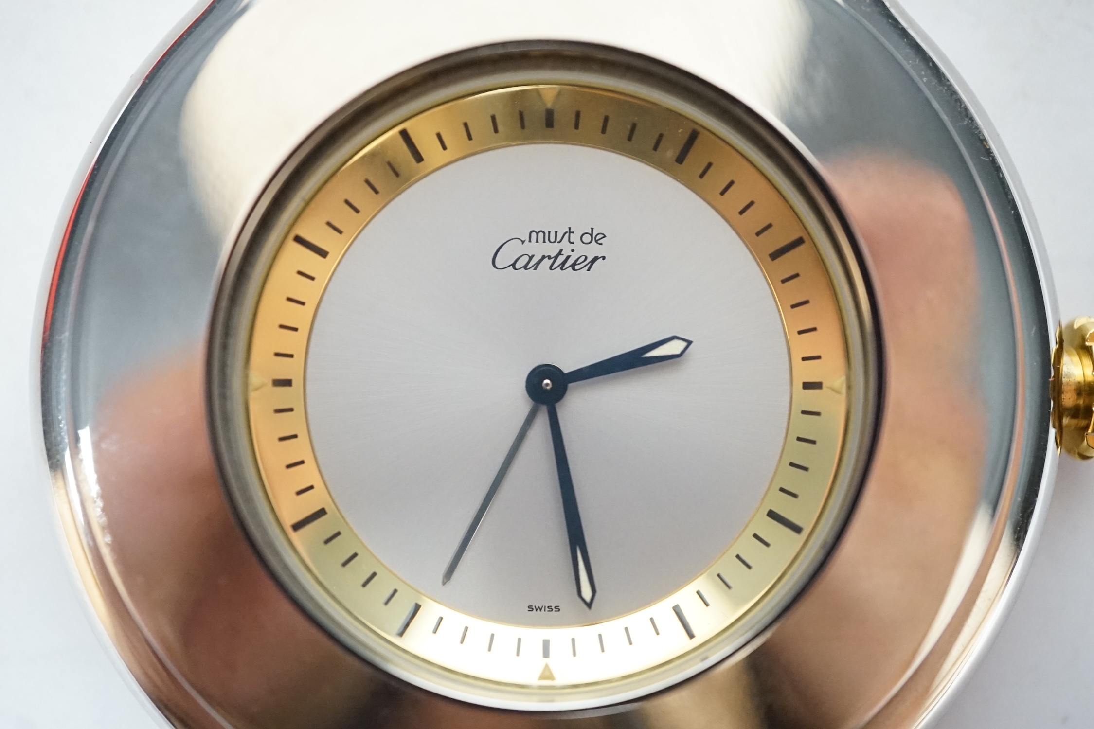 A Must de Cartier travelling alarm clock with pouch and case, 6cm wide. Condition - good, not tested